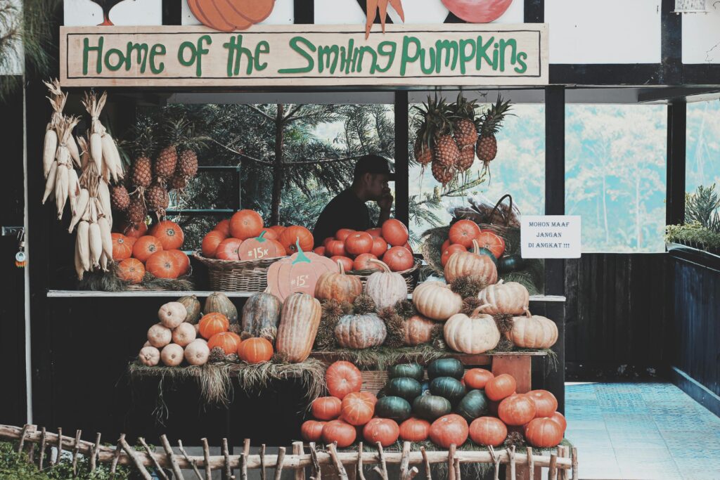 A vibrant fruit and vegetable stand featuring pumpkins in Bandung, Indonesia.