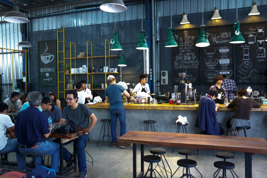 A lively coffee shop with patrons and baristas engaging in a vibrant atmosphere.